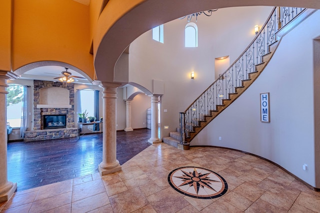 5016 Frontier Rd NE, Rio Rancho, NM 87144 - entryway featuring a ceiling fan, arched walkways, a towering ceiling, a fireplace, and decorative columns
