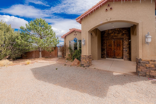 5016 Frontier Rd NE, Rio Rancho, NM 87144 - entrance to property with stone siding, a tile roof, fence, and stucco siding