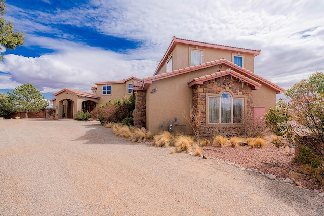 5016 Frontier Rd NE, Rio Rancho, NM 87144 - view of front of home with stucco siding, stone siding, and a tiled roof