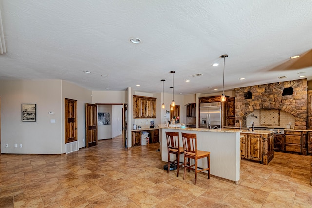 5016 Frontier Rd NE, Rio Rancho, NM 87144 - kitchen with recessed lighting, a large island, built in fridge, hanging light fixtures, and a breakfast bar area