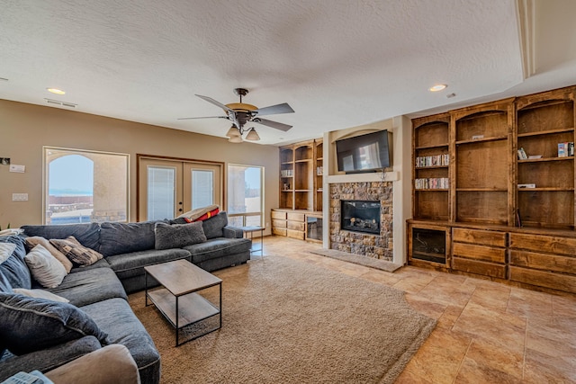 5016 Frontier Rd NE, Rio Rancho, NM 87144 - living area with a stone fireplace, a textured ceiling, built in features, and ceiling fan