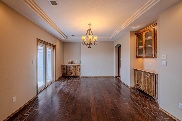 5016 Frontier Rd NE, Rio Rancho, NM 87144 - unfurnished dining area featuring a chandelier, arched walkways, a tray ceiling, baseboards, and dark wood-style flooring