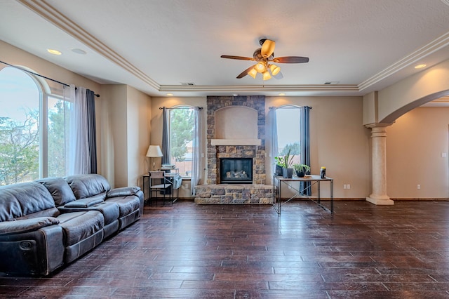 5016 Frontier Rd NE, Rio Rancho, NM 87144 - living room with a tray ceiling, arched walkways, ornate columns, a ceiling fan, and a fireplace