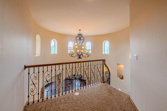 5016 Frontier Rd NE, Rio Rancho, NM 87144 - corridor featuring a textured wall, carpet floors, and an inviting chandelier