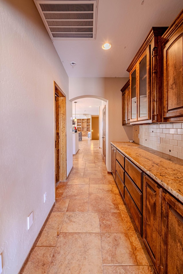 5016 Frontier Rd NE, Rio Rancho, NM 87144 - hallway featuring recessed lighting, stone finish floor, visible vents, arched walkways, and baseboards