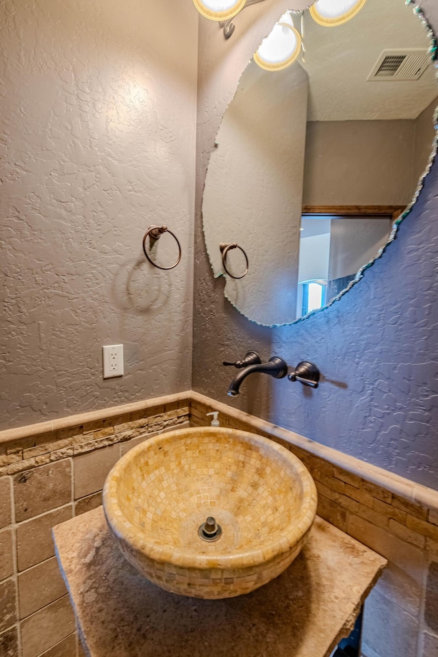 5016 Frontier Rd NE, Rio Rancho, NM 87144 - bathroom with a sink, a textured wall, a wainscoted wall, tile patterned flooring, and visible vents