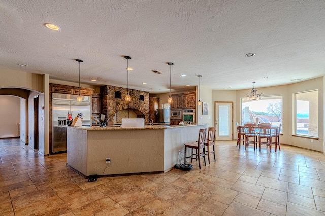 5016 Frontier Rd NE, Rio Rancho, NM 87144 - kitchen with arched walkways, stainless steel built in refrigerator, a textured ceiling, and visible vents
