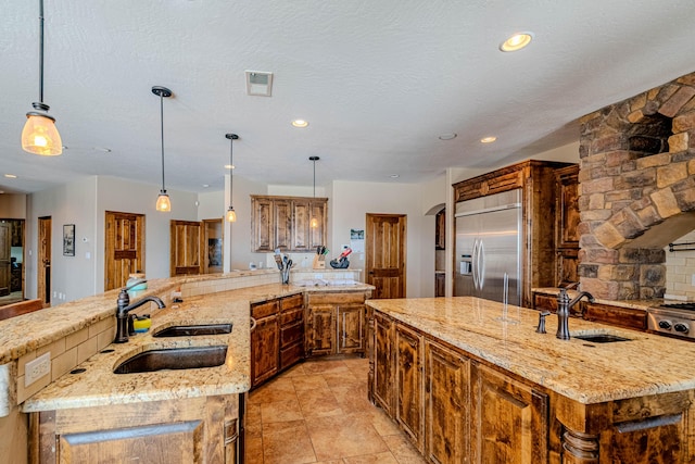 5016 Frontier Rd NE, Rio Rancho, NM 87144 - kitchen featuring light stone countertops, a large island with sink, stainless steel built in refrigerator, and a sink