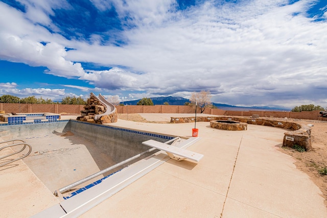 5016 Frontier Rd NE, Rio Rancho, NM 87144 - view of pool with a water slide, a fenced in pool, a fenced backyard, a patio, and an outdoor fire pit
