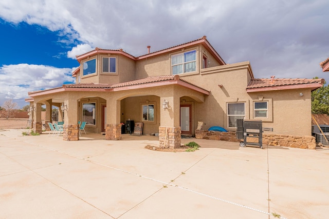 5016 Frontier Rd NE, Rio Rancho, NM 87144 - rear view of property featuring stucco siding, a tiled roof, and a patio