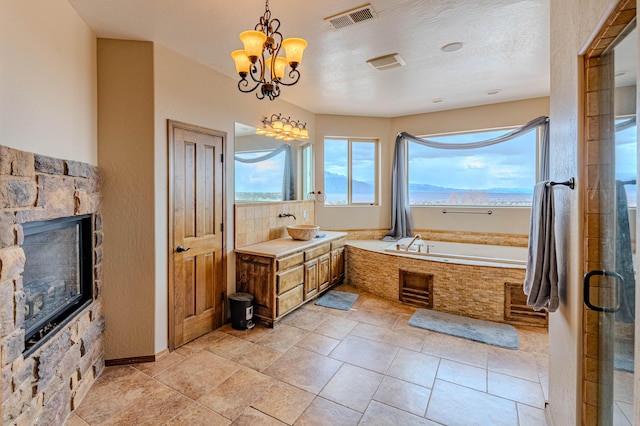 5016 Frontier Rd NE, Rio Rancho, NM 87144 - bathroom with a bath, visible vents, a notable chandelier, vanity, and a fireplace