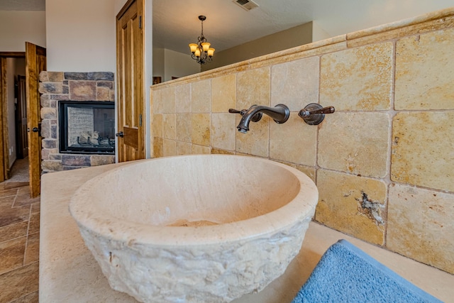 5016 Frontier Rd NE, Rio Rancho, NM 87144 - full bath with a fireplace, visible vents, and an inviting chandelier