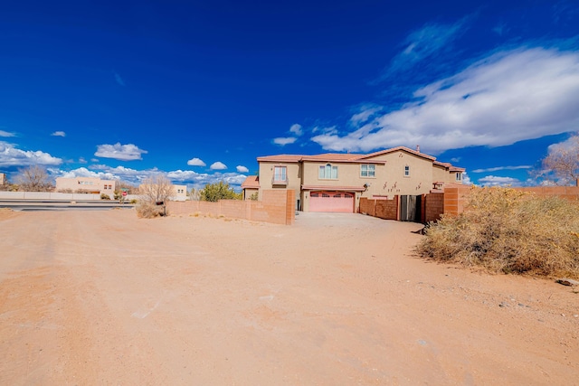 5016 Frontier Rd NE, Rio Rancho, NM 87144 - view of yard with dirt driveway, an attached garage, and fence