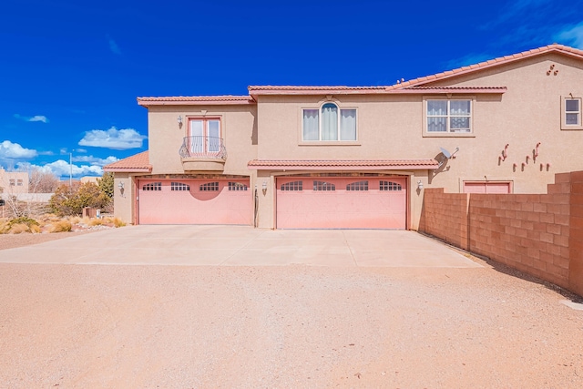 5016 Frontier Rd NE, Rio Rancho, NM 87144 - view of front of home with a tiled roof, a balcony, stucco siding, driveway, and a garage