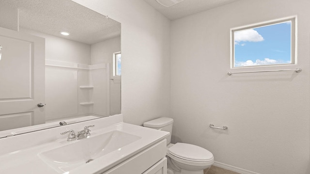 bathroom with walk in shower, vanity, toilet, a textured ceiling, and baseboards