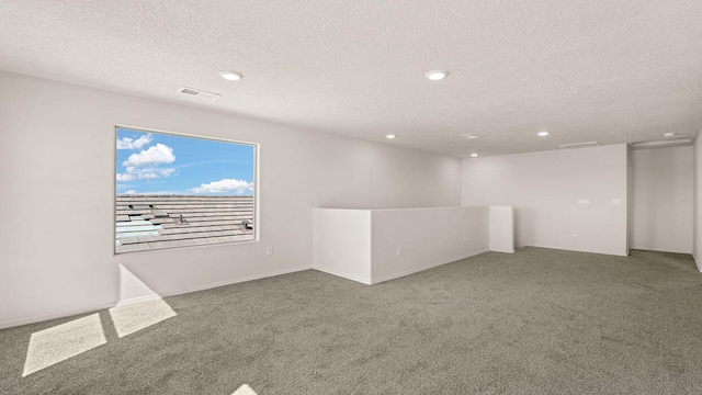 spare room with recessed lighting, a textured ceiling, carpet, and visible vents