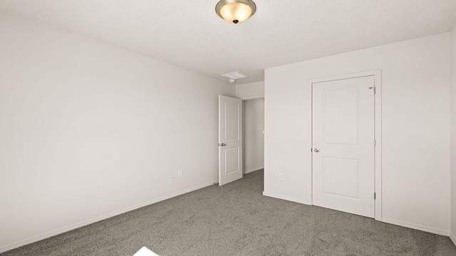 unfurnished bedroom featuring carpet floors, baseboards, and a textured ceiling