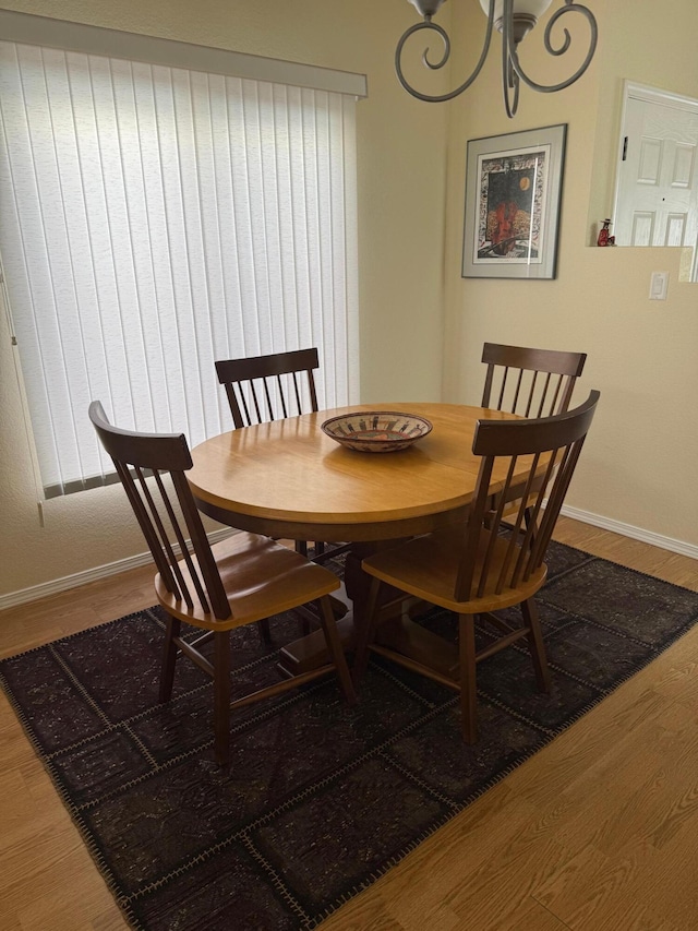 4449 Sunflower Ct SE, Rio Rancho, NM 87124 - dining space featuring wood finished floors, a chandelier, and baseboards