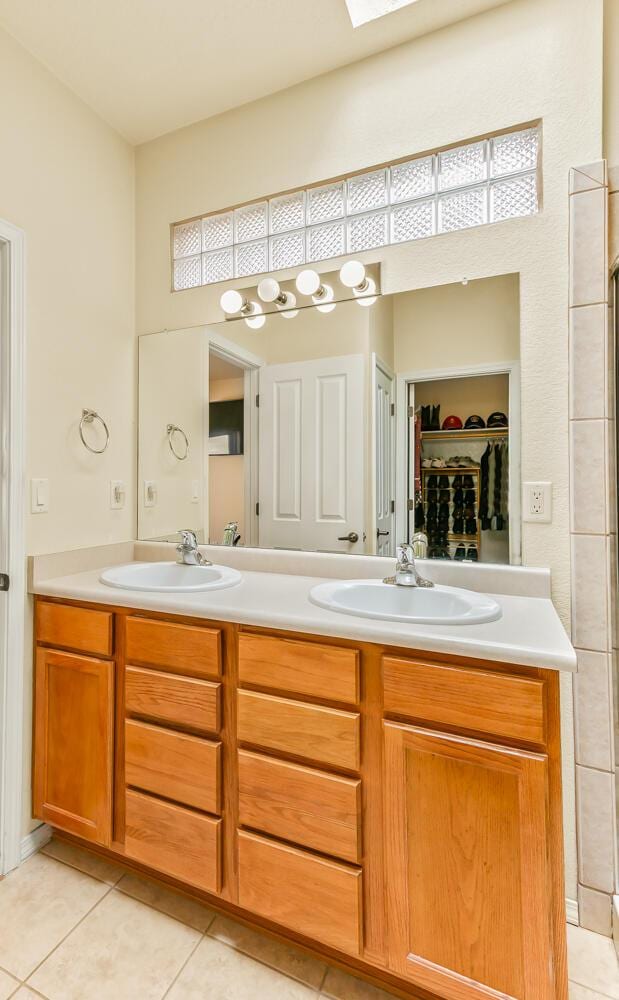 4449 Sunflower Ct SE, Rio Rancho, NM 87124 - bathroom featuring tile patterned floors, double vanity, and a spacious closet
