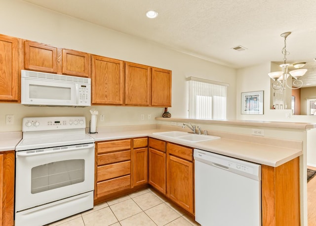4449 Sunflower Ct SE, Rio Rancho, NM 87124 - kitchen with white appliances, a sink, a peninsula, a chandelier, and brown cabinets