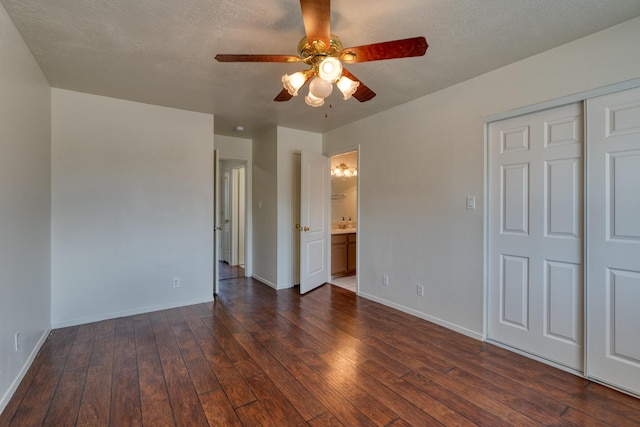 2028 Clearwater Loop NE, Rio Rancho, NM 87144 - unfurnished bedroom featuring dark wood finished floors, baseboards, a closet, ensuite bathroom, and a textured ceiling