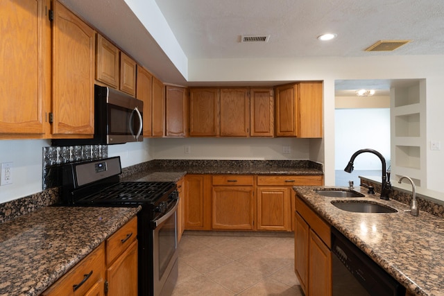 2028 Clearwater Loop NE, Rio Rancho, NM 87144 - kitchen with appliances with stainless steel finishes, a sink, brown cabinets, dark stone counters, and recessed lighting