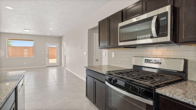 kitchen with stone counters, baseboards, backsplash, and appliances with stainless steel finishes