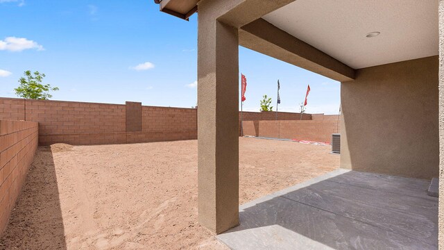 view of yard featuring a fenced backyard, a patio area, and central AC