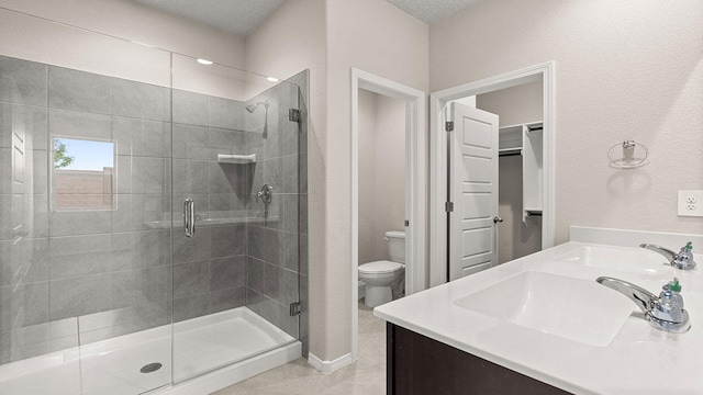 full bath with double vanity, toilet, a stall shower, and a sink