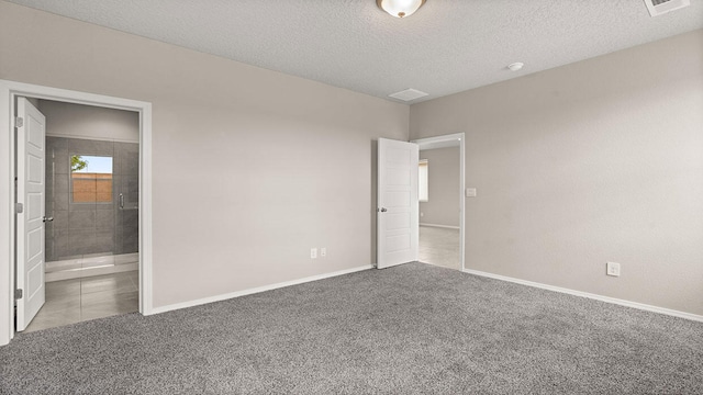 unfurnished bedroom with a textured ceiling, carpet flooring, and baseboards