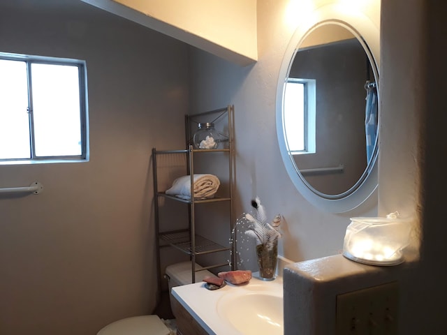 half bathroom featuring vanity and toilet