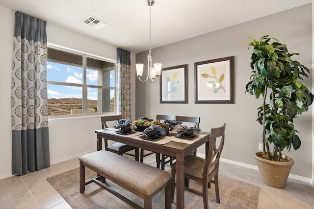 dining area with baseboards, visible vents, a notable chandelier, and light tile patterned floors