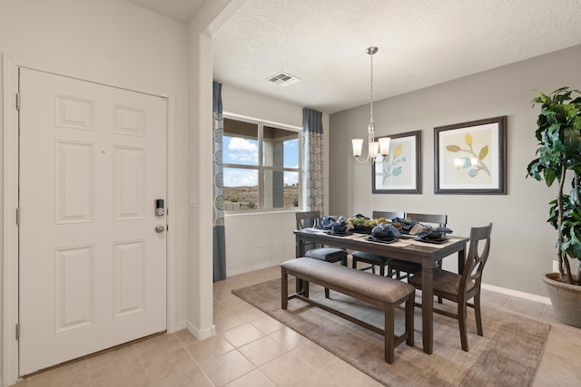 dining space with visible vents, light tile patterned floors, baseboards, a textured ceiling, and a notable chandelier