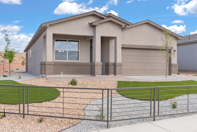 ranch-style home featuring stucco siding, driveway, a garage, and a fenced front yard