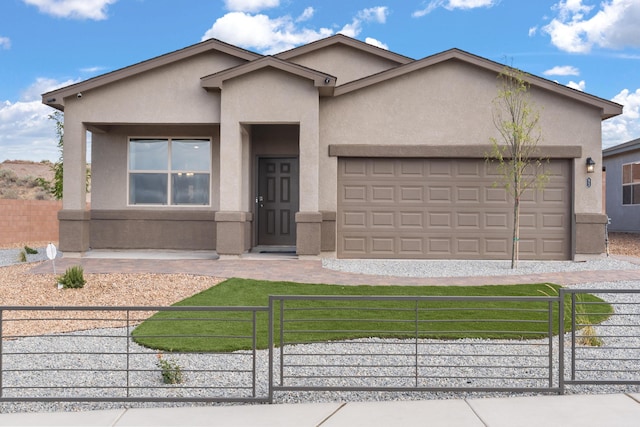 ranch-style house featuring a garage, a fenced front yard, and stucco siding