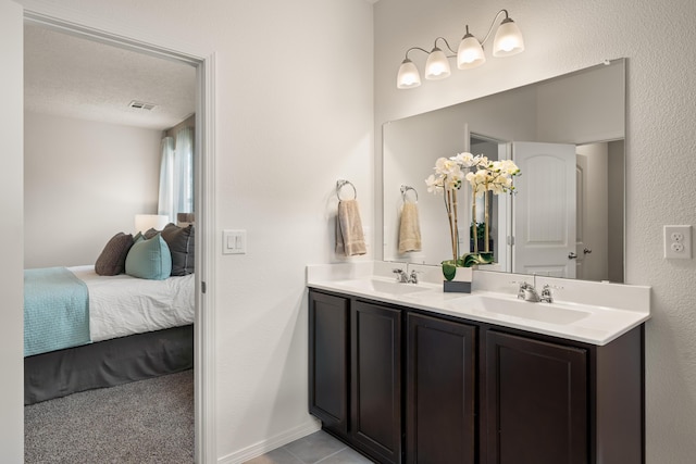 ensuite bathroom with double vanity, a sink, visible vents, and ensuite bathroom