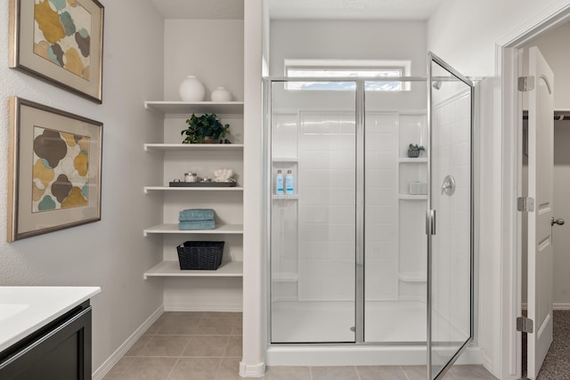 bathroom with a shower stall, tile patterned floors, and vanity