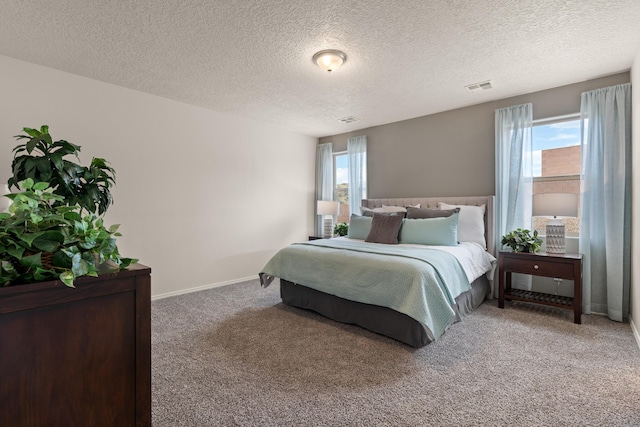 bedroom featuring a textured ceiling, carpet, and visible vents