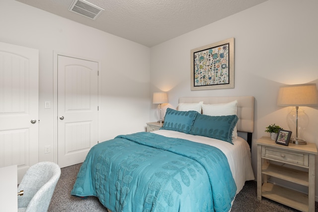 bedroom with a textured ceiling, carpet, and visible vents