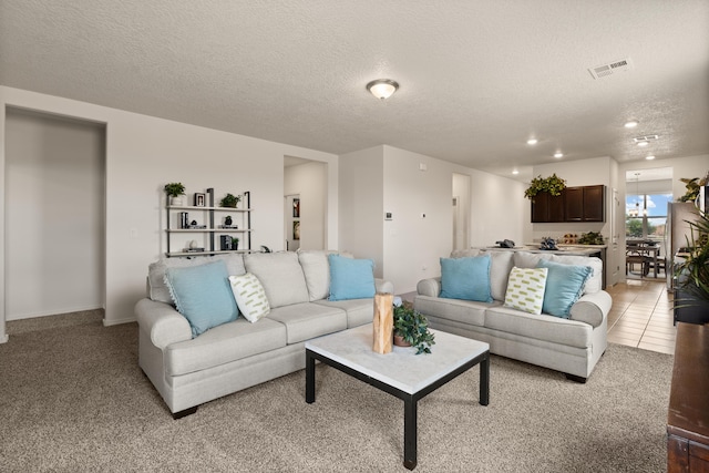 living area with recessed lighting, a textured ceiling, visible vents, and light carpet