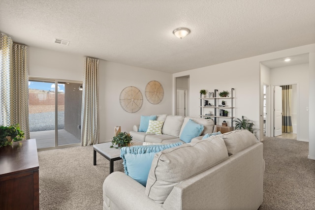 carpeted living area featuring visible vents and a textured ceiling