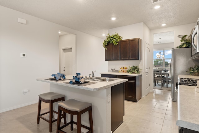 kitchen featuring dark brown cabinets, a sink, a textured ceiling, and light countertops