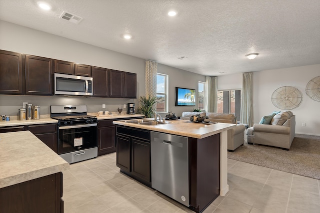 kitchen featuring a sink, open floor plan, light countertops, appliances with stainless steel finishes, and visible vents
