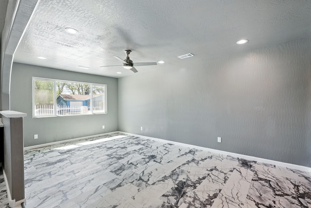 empty room with a ceiling fan, a textured ceiling, marble finish floor, visible vents, and recessed lighting