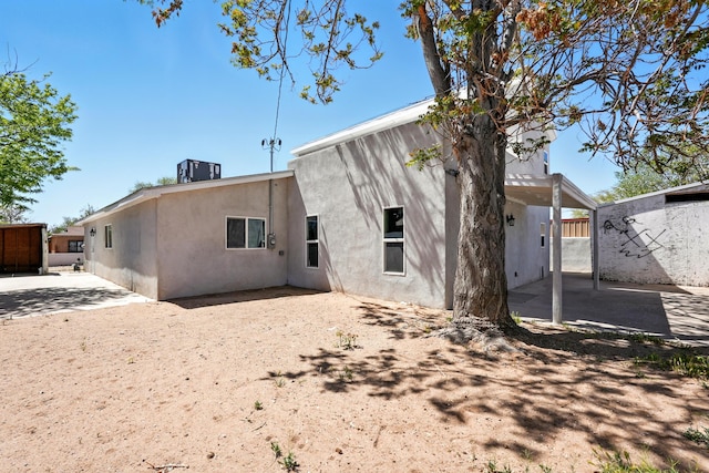 back of house with central air condition unit, a patio area, and stucco siding