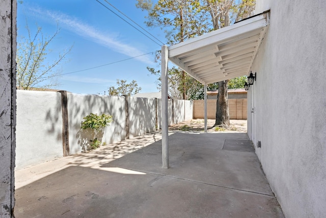 view of patio / terrace featuring a carport and a fenced backyard