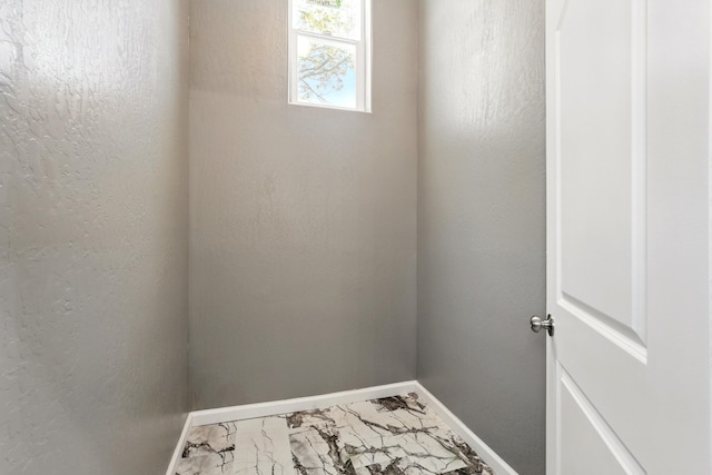 interior space featuring marble finish floor and baseboards