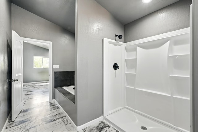 bathroom with a bath, a textured wall, marble finish floor, and a stall shower