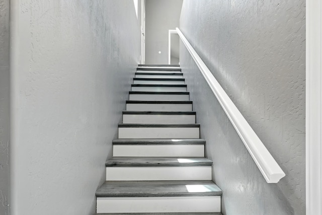 staircase with a textured wall