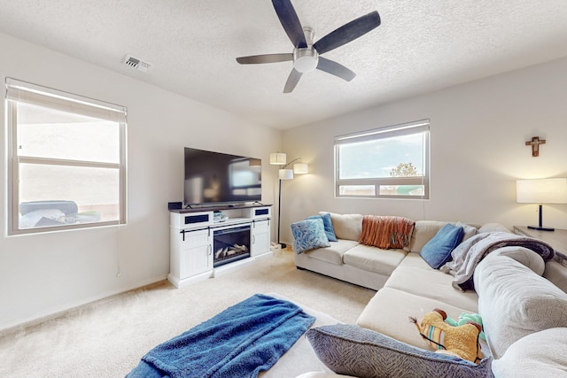 7105 Napoleon Rd NE, Rio Rancho, NM 87144 - living area with light colored carpet, a ceiling fan, a textured ceiling, a fireplace, and baseboards